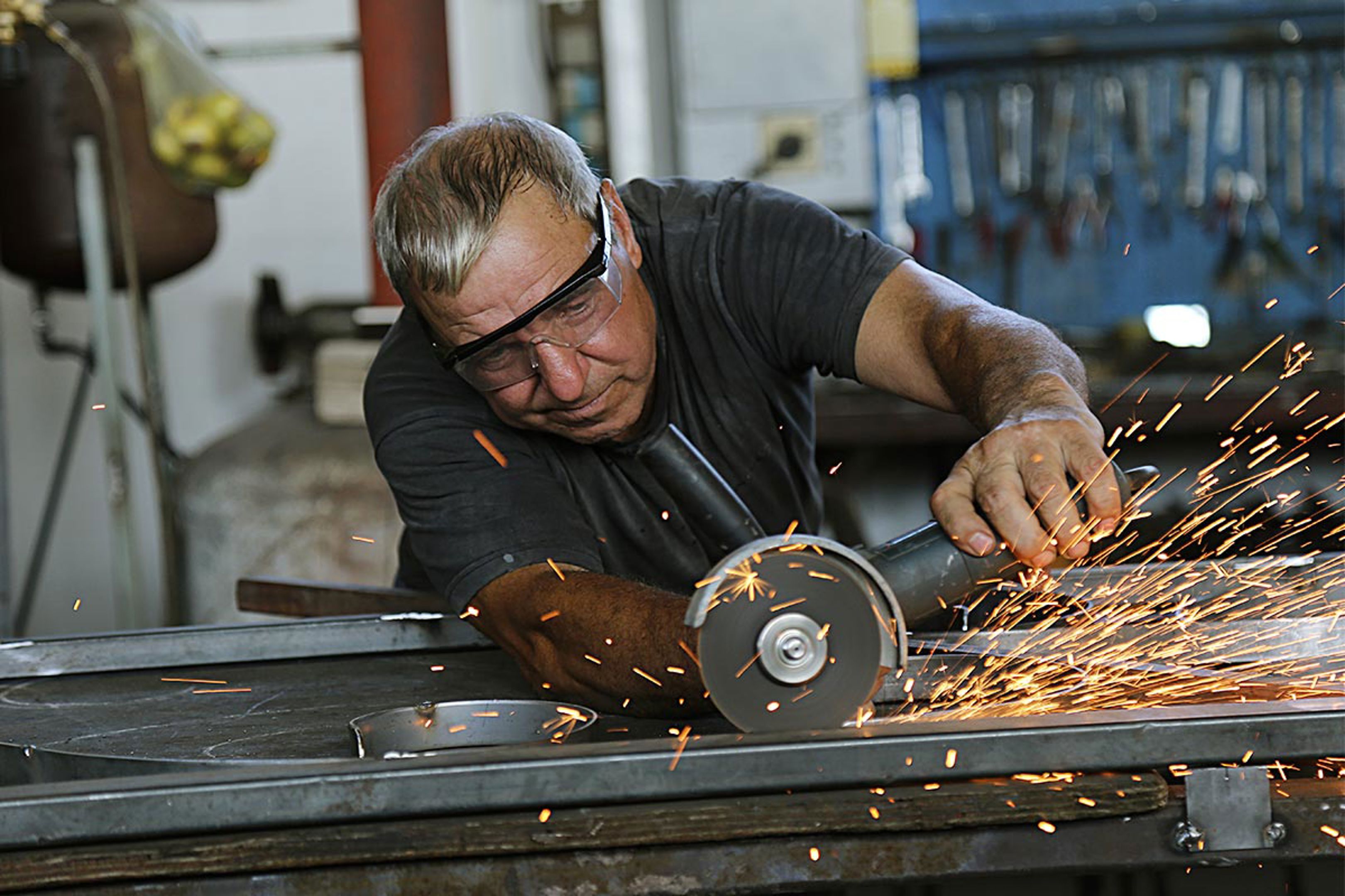 Man using grinder with sparks 