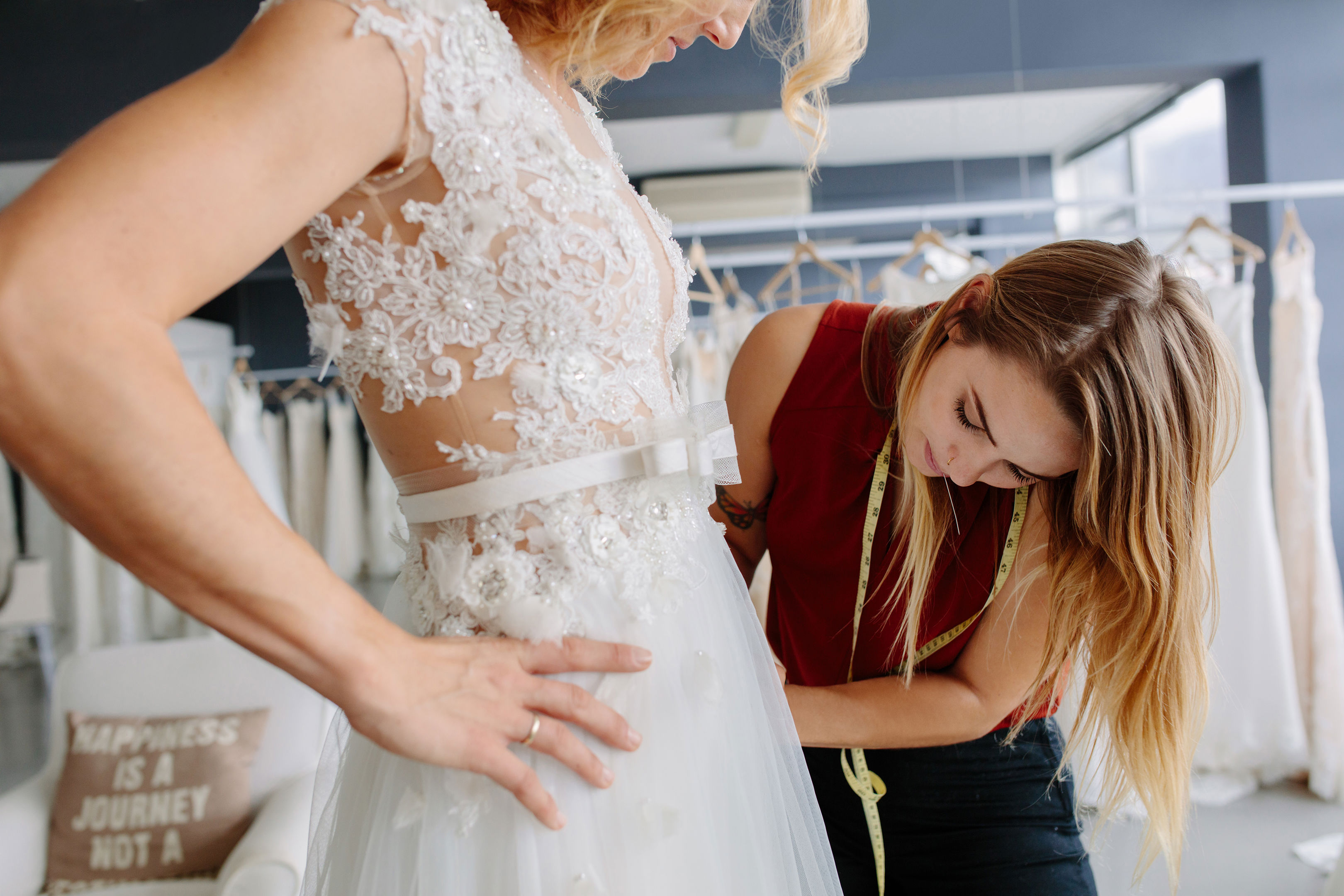 Dress Designer Fitting Wedding Gown To Woman