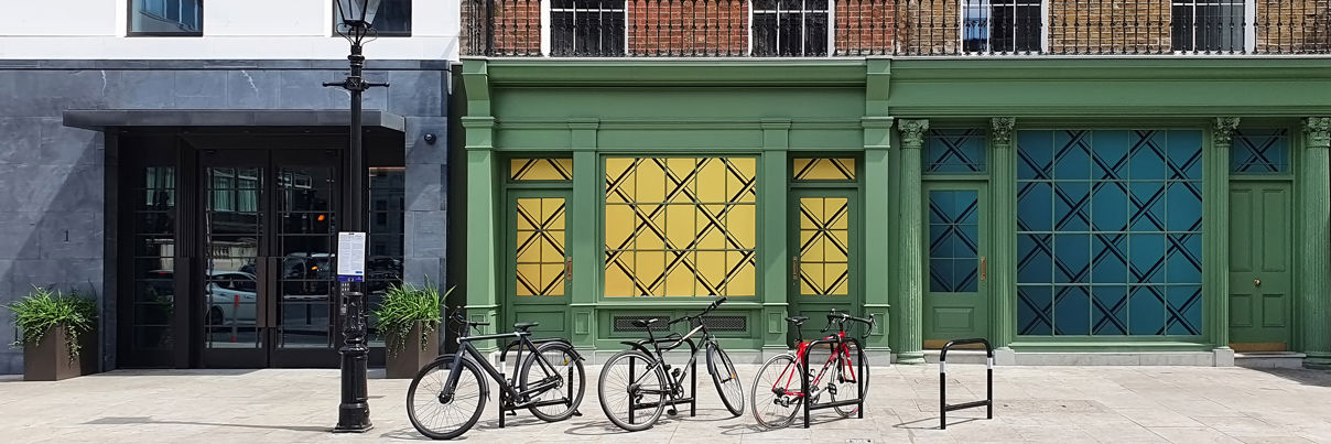 Bicycles On Bike Racks Along Sidewalk In Residential Area