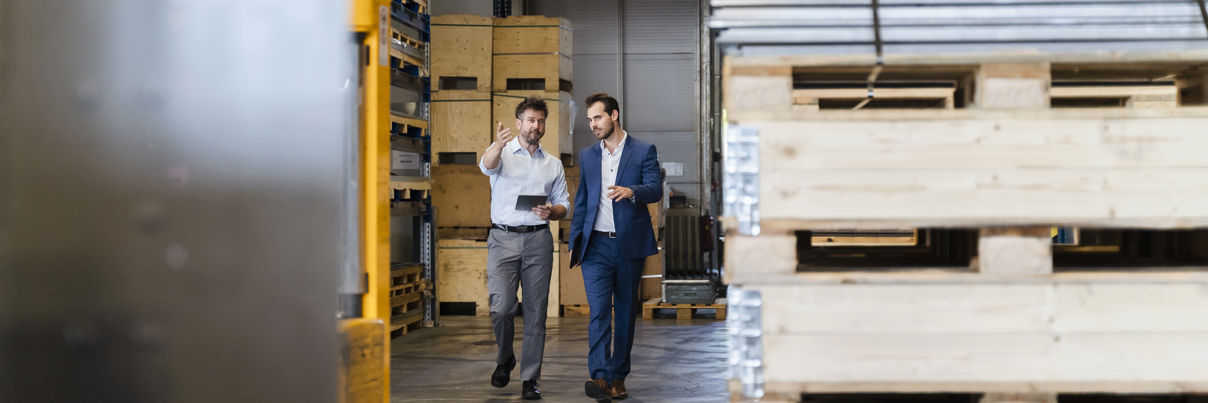 Businessman And Colleague Inspecting Warehouse