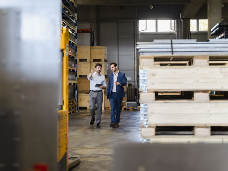 Businessman And Colleague Inspecting Warehouse