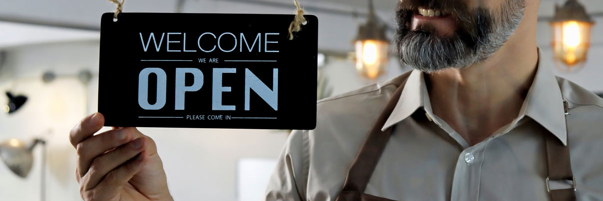 Man In Apron Putting Nameplate On The Entrance Door