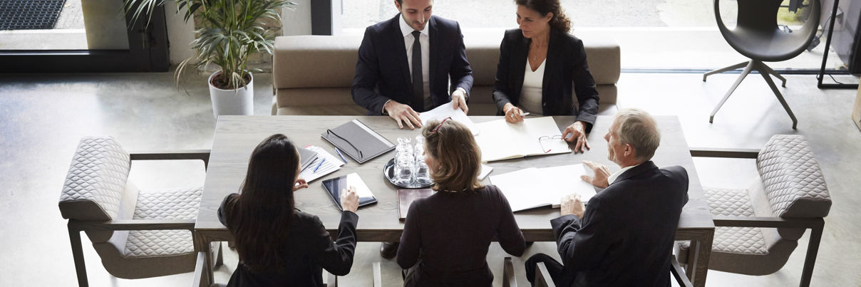 High Angle View Of Financial Advisors And Customers Discussing During Meeting At Law Firm