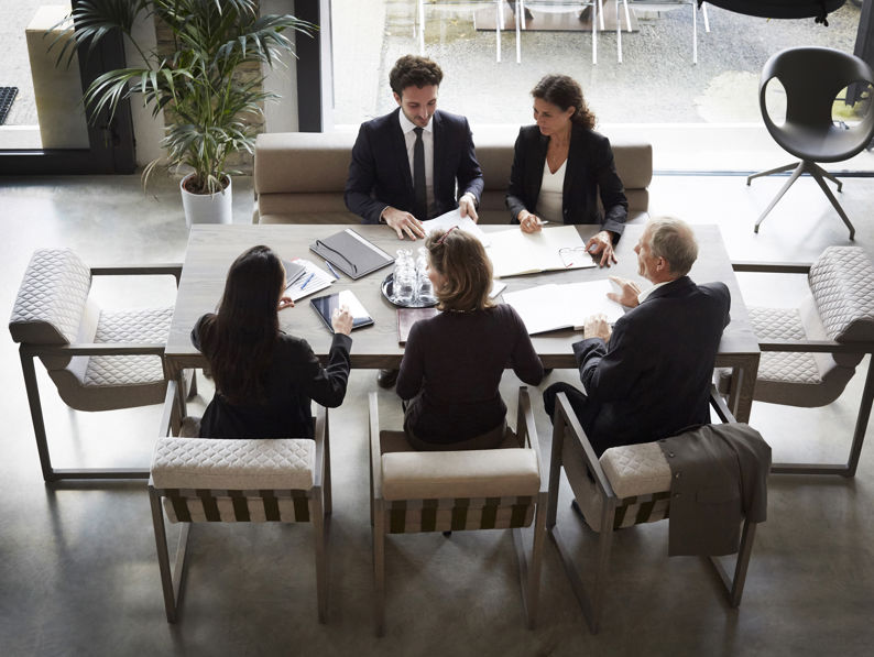 High Angle View Of Financial Advisors And Customers Discussing During Meeting At Law Firm
