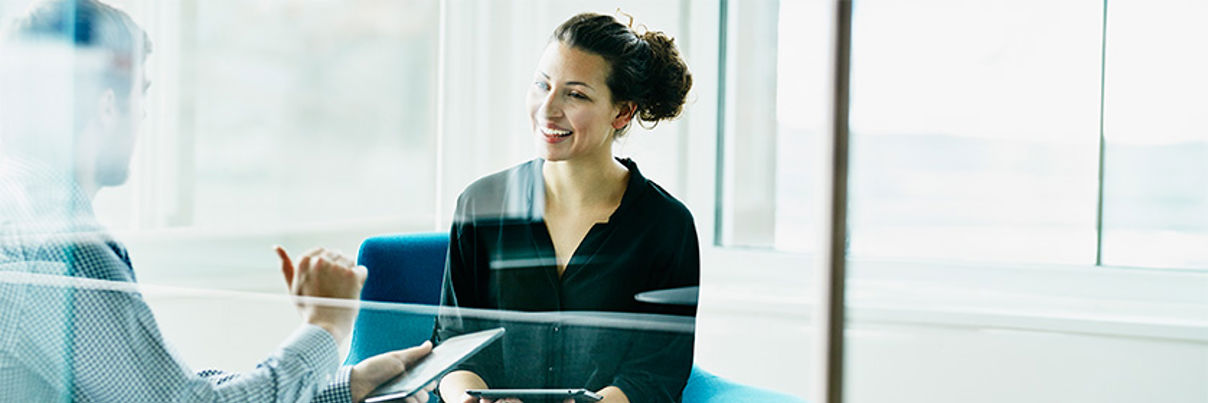 Two Colleagues Discussing Project On Digital Tablets