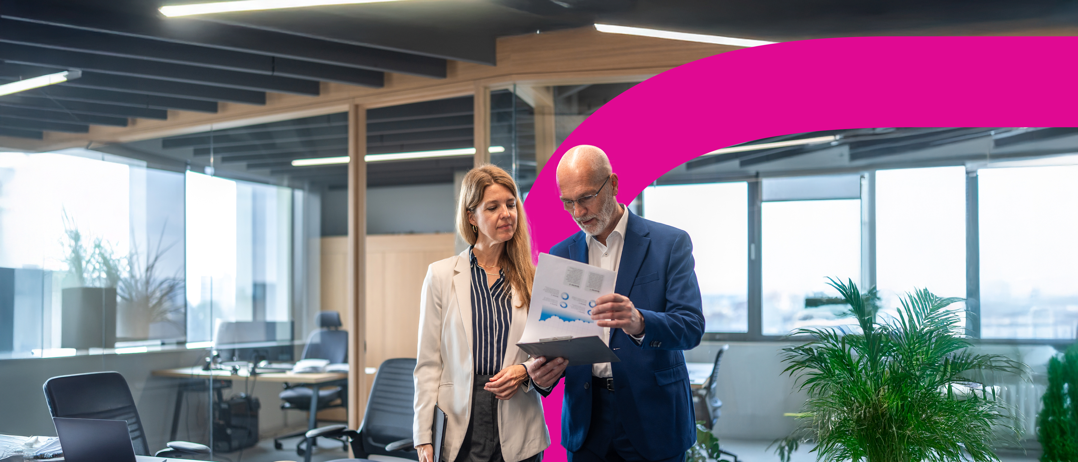 A close-up of a lion’s face and mane, looking directly at the camera with an alert expression. The background is blurred, drawing focus to the lion’s intense eyes and detailed fur.