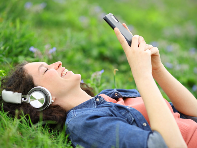 Happy Woman Listening With Headphones And Phone
