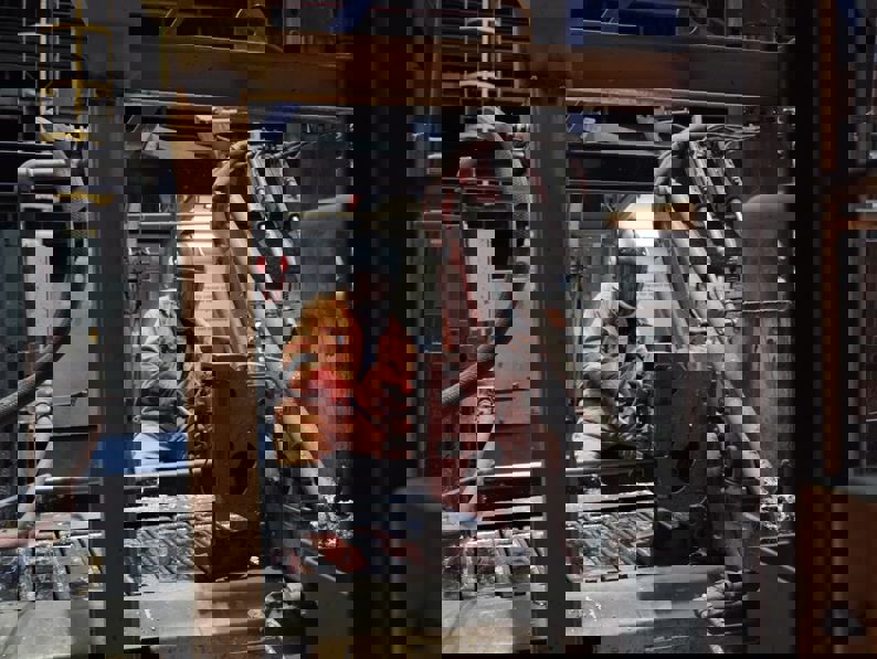 The image appears distorted with digital glitches, making the scene unclear. Horizontal and vertical lines of pixelation obscure the details, and colors such as gray, black, orange, and brown are visible throughout the image.