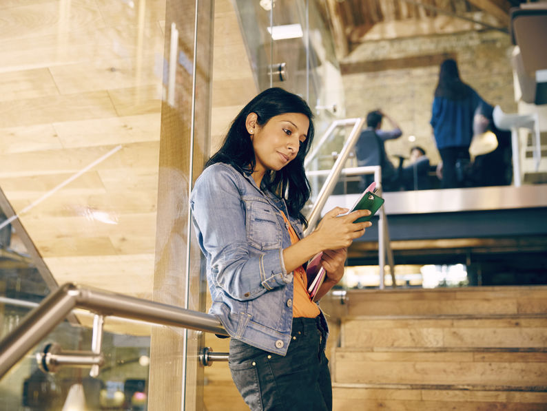 Professional Checks Her Smartphone In Modern Office