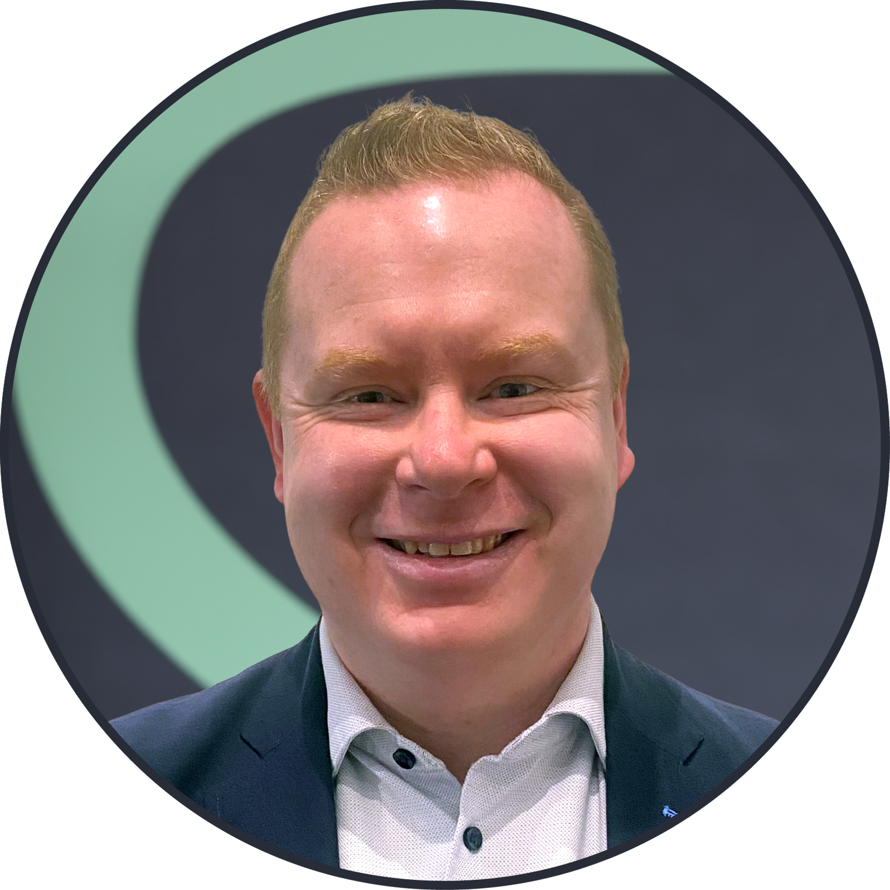 A smiling man with short, light hair in a suit jacket and collared shirt stands in front of a dark background with a large, light green curved shape.
