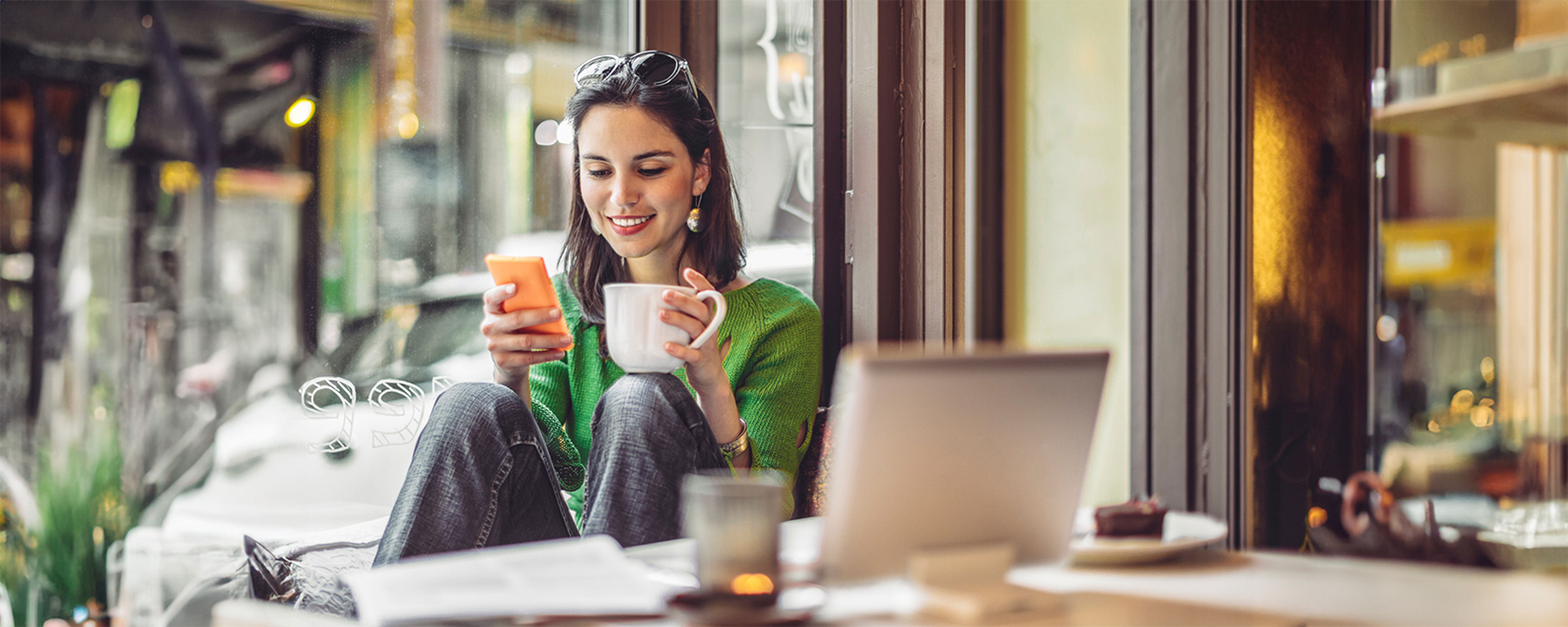 Lady interacting with device in a coffee shop
