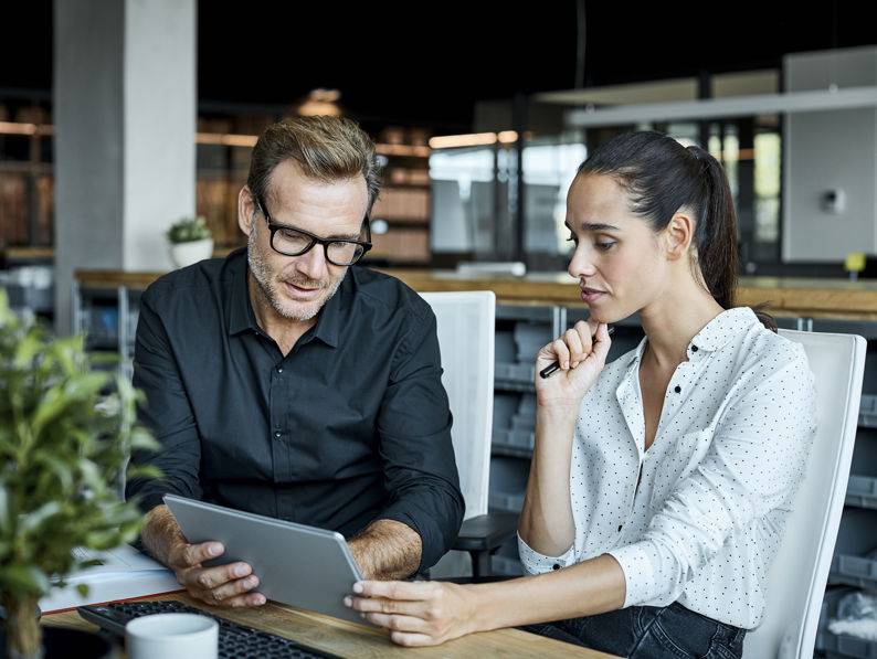 Colleagues Using Tablet PC In Textile Factory