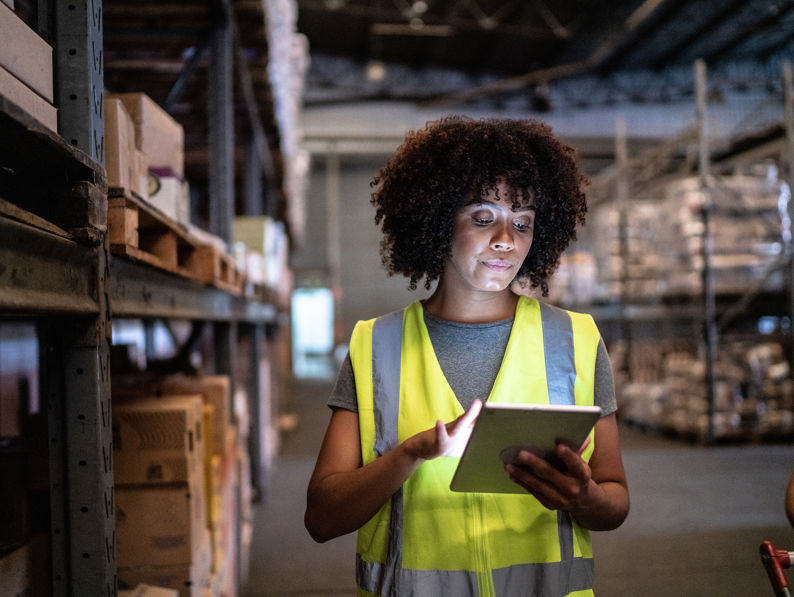 Woman Using The Digital Tablet In A Warehouse
