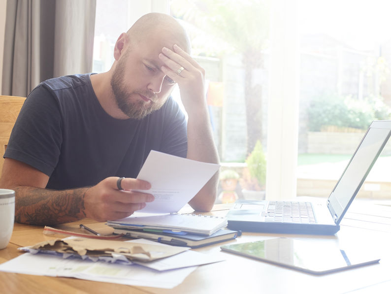 Man Sat At Dining Room Table Working From Home