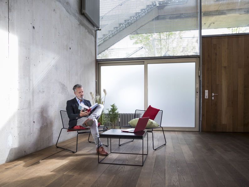 Businessman Sitting In A Loft At Concrete Wall