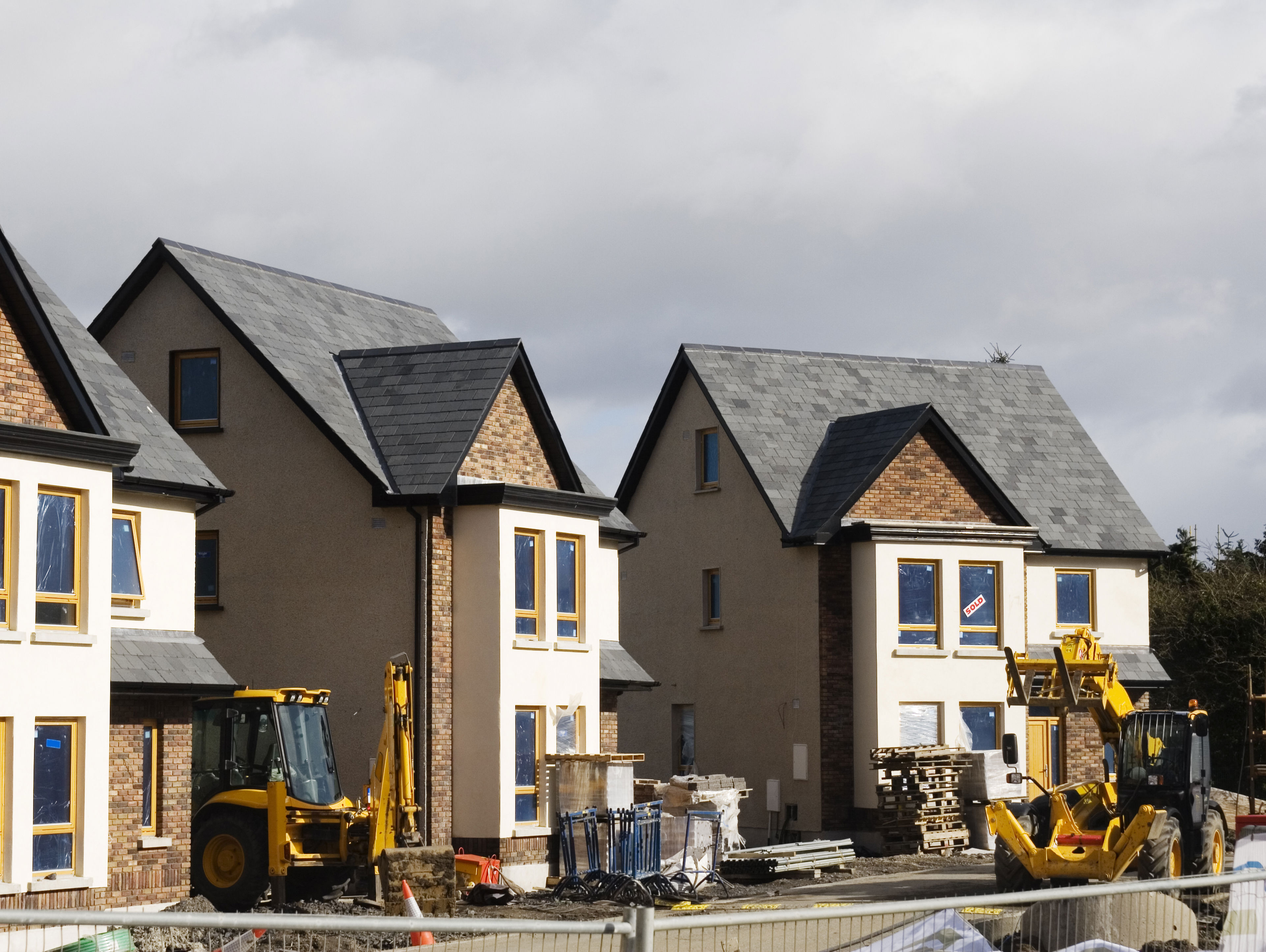 Three detached new build properties during construction.