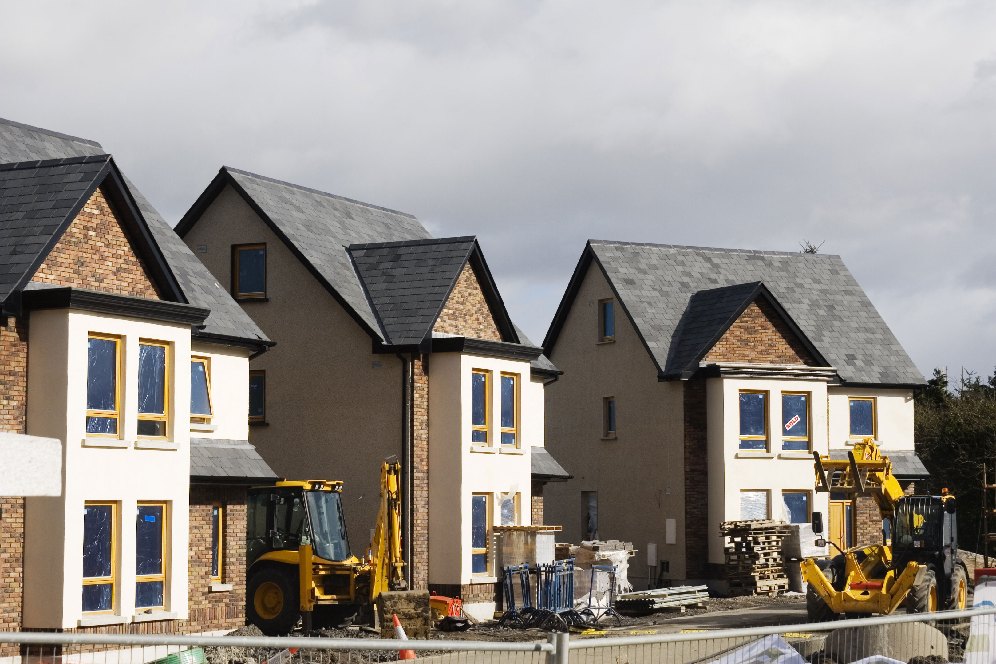 Three detached new build properties during construction.